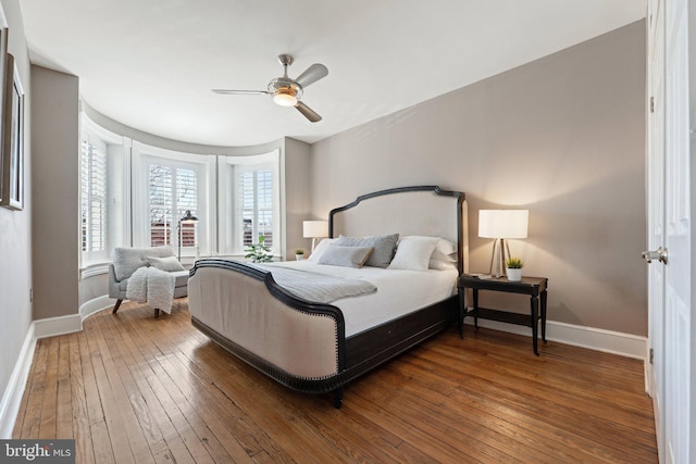 bedroom with baseboards, wood-type flooring, and a ceiling fan