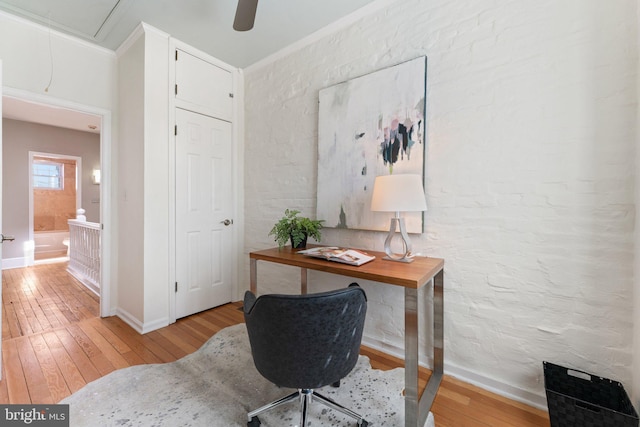 office area featuring attic access, baseboards, light wood finished floors, and ornamental molding