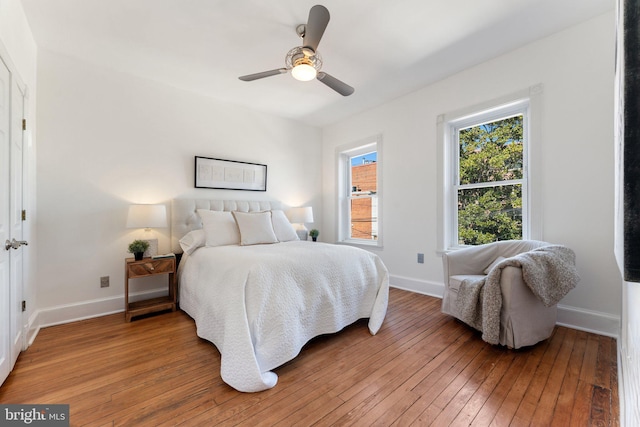 bedroom with baseboards, light wood-style floors, and a ceiling fan