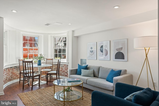 living room with dark wood-style floors, visible vents, and recessed lighting