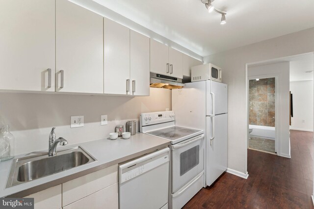 kitchen featuring white appliances, dark wood finished floors, a sink, light countertops, and under cabinet range hood