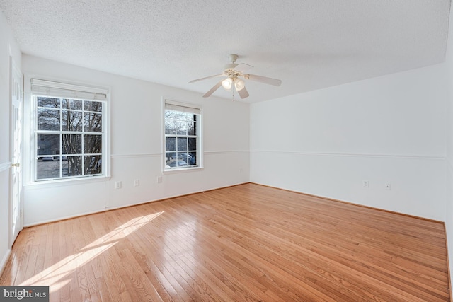 unfurnished room featuring ceiling fan, hardwood / wood-style flooring, and a textured ceiling