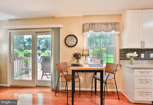 dining space featuring baseboards and light wood finished floors