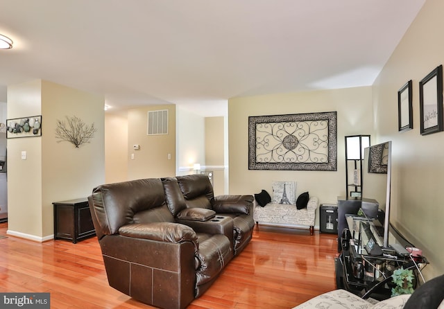 living room with visible vents, baseboards, and light wood-style flooring