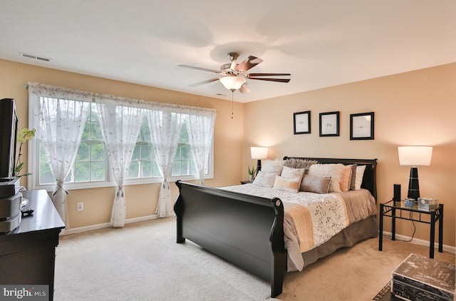 bedroom with visible vents, light colored carpet, a ceiling fan, and baseboards