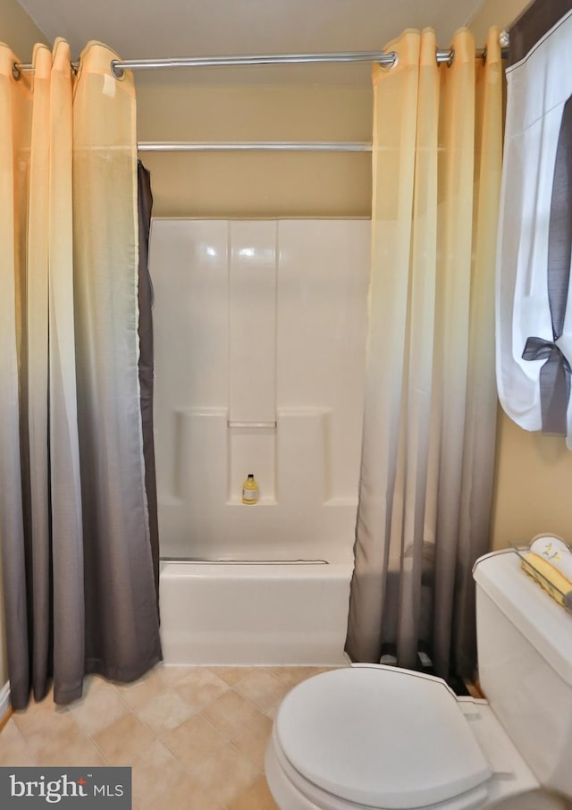 full bath featuring tile patterned floors, shower / bathtub combination with curtain, and toilet