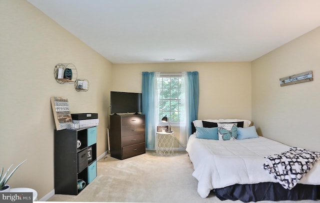 bedroom with light carpet and baseboards