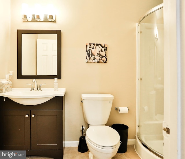 bathroom featuring baseboards, vanity, a shower stall, and toilet