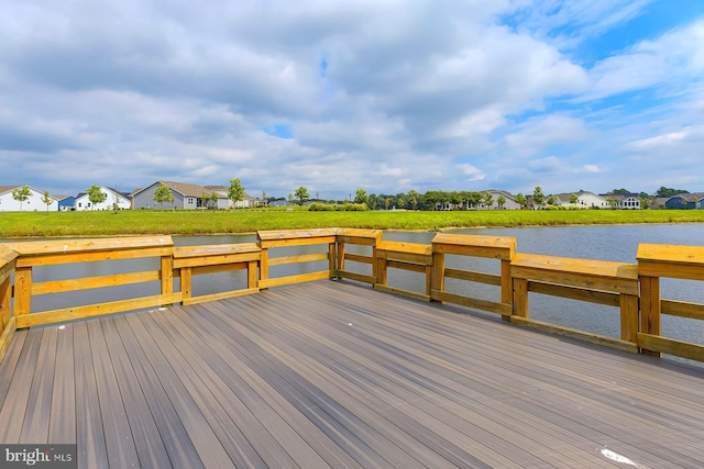 wooden terrace featuring a residential view and a water view