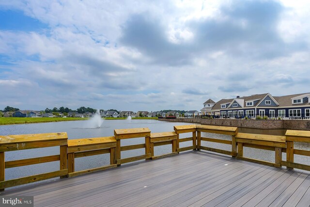 view of dock with a residential view and a water view