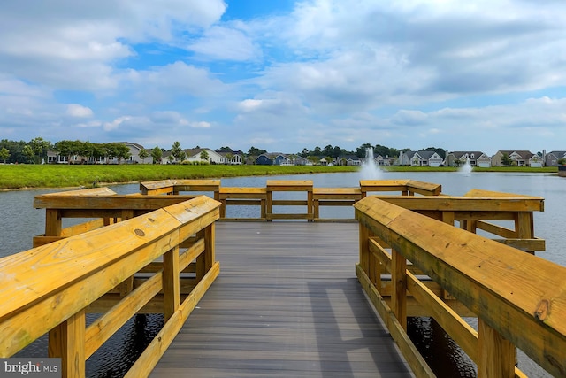 view of dock with a residential view and a water view