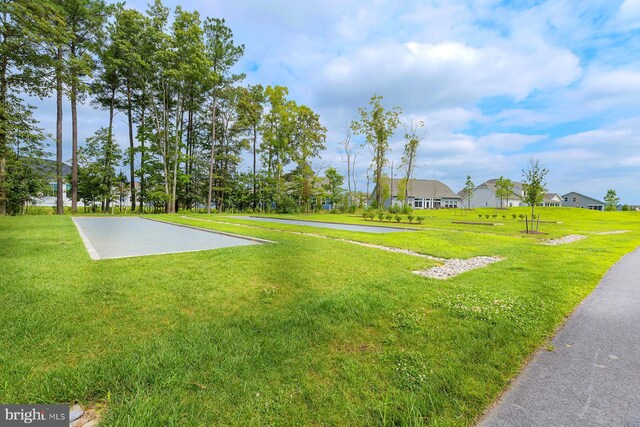 view of community featuring community basketball court, a lawn, and a residential view