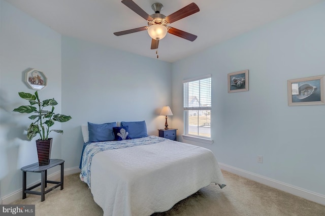 bedroom with light colored carpet, baseboards, and ceiling fan