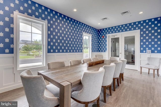 dining space featuring visible vents, wainscoting, french doors, and wallpapered walls