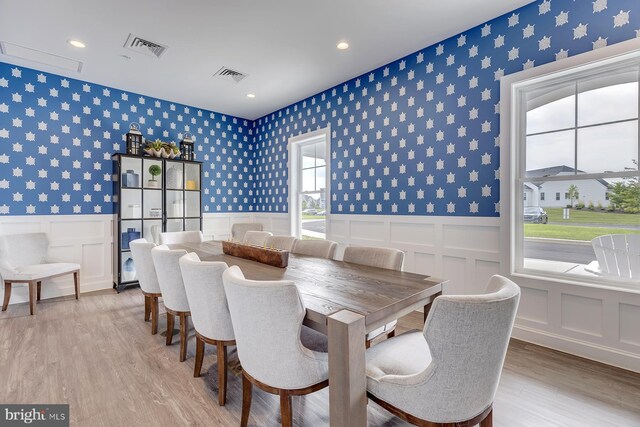 dining room with visible vents, wallpapered walls, and a wainscoted wall