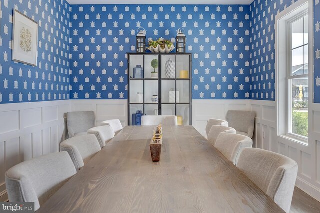 dining area featuring wallpapered walls and a wainscoted wall