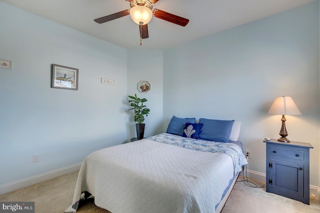 bedroom featuring baseboards, light colored carpet, and a ceiling fan