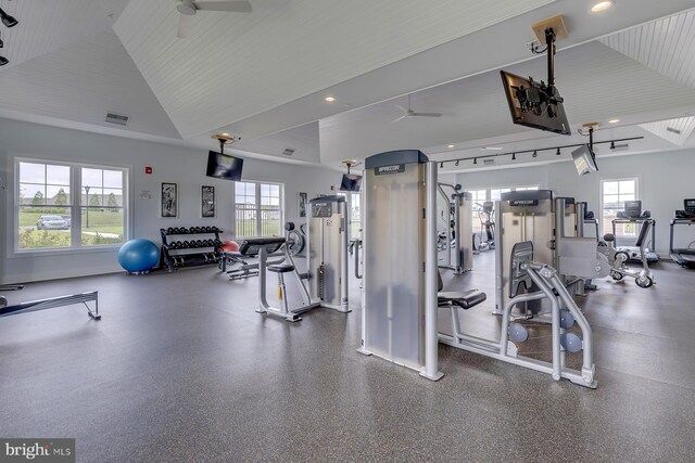 exercise room with visible vents, a healthy amount of sunlight, a ceiling fan, and vaulted ceiling