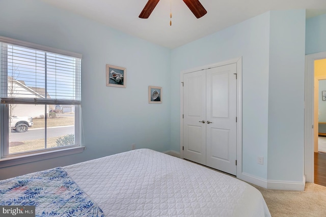 carpeted bedroom with a closet, a ceiling fan, and baseboards