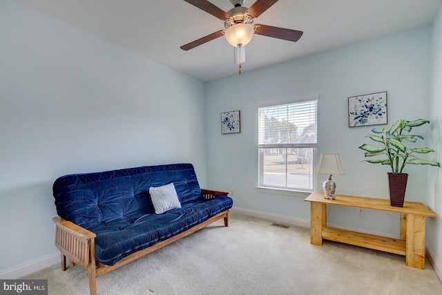 sitting room featuring carpet, baseboards, and ceiling fan