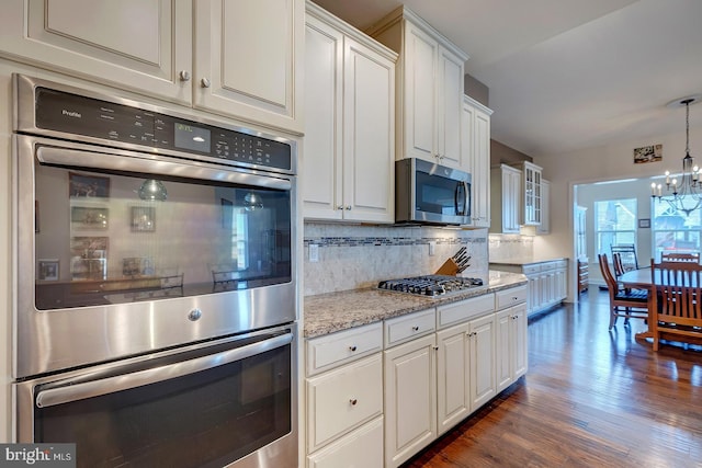 kitchen with stainless steel appliances, tasteful backsplash, and white cabinetry