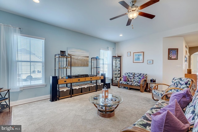 carpeted living area with baseboards, recessed lighting, arched walkways, and ceiling fan