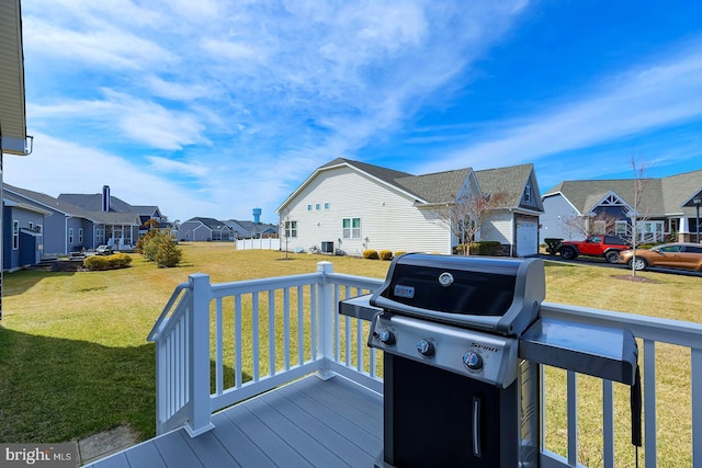 wooden deck with a residential view, a lawn, and area for grilling