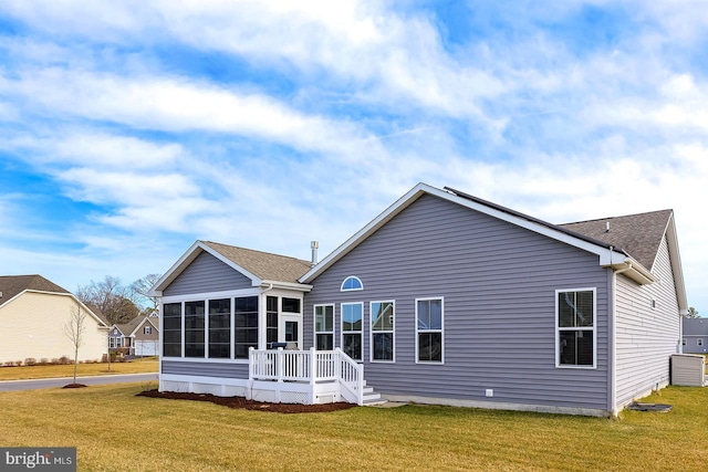 back of house with a yard and a sunroom