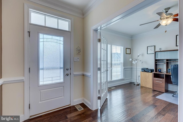 foyer featuring visible vents, dark wood-type flooring, ornamental molding, and wainscoting