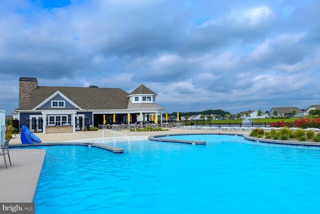 pool with a patio and fence