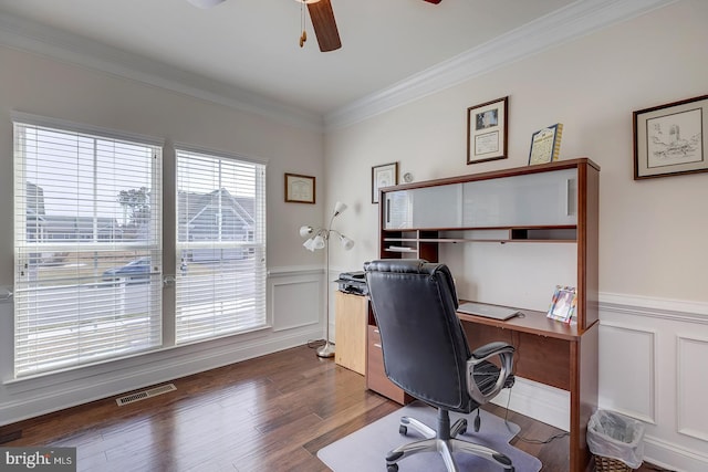 office space with visible vents, dark wood finished floors, ornamental molding, wainscoting, and a ceiling fan