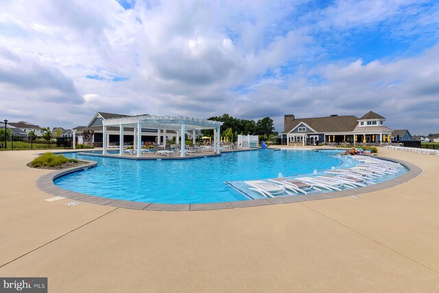 community pool featuring a patio area, fence, and a pergola