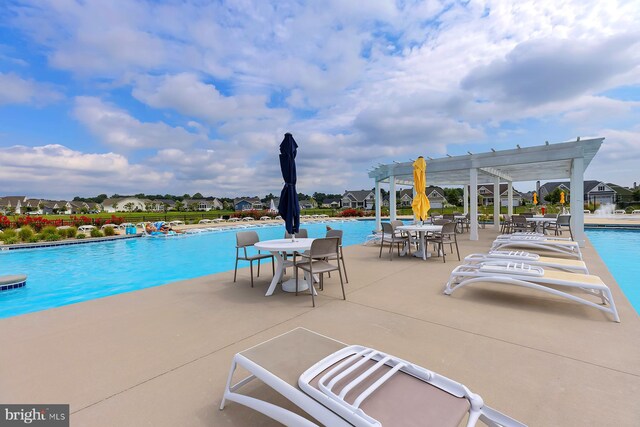 pool with a patio area and a pergola