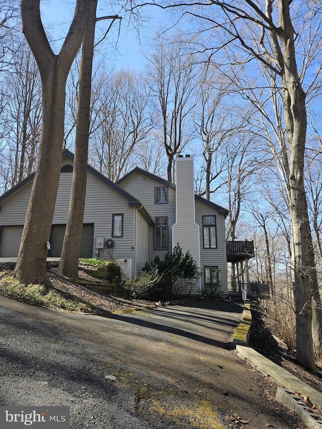 view of front of house with an attached garage and a chimney