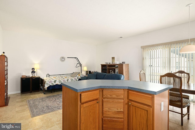 kitchen featuring a kitchen island, dark countertops, open floor plan, light tile patterned flooring, and hanging light fixtures