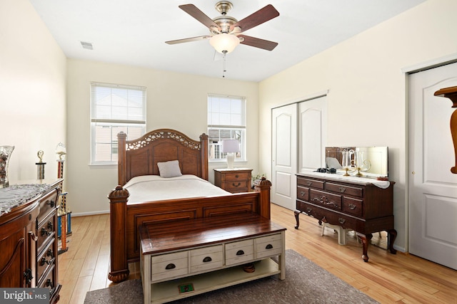 bedroom with multiple windows, visible vents, light wood-type flooring, and cooling unit