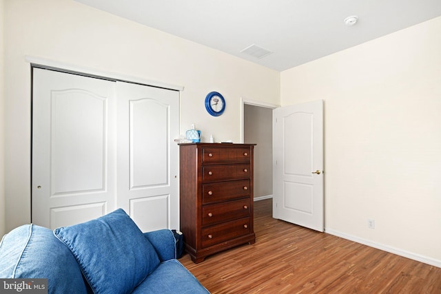 living area featuring wood finished floors, visible vents, and baseboards