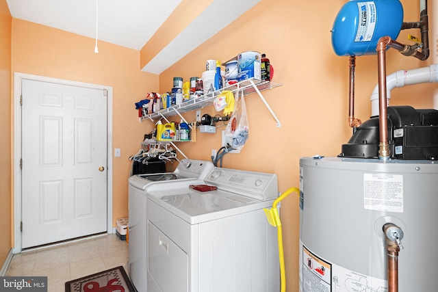 washroom with gas water heater, light tile patterned floors, laundry area, and washer and dryer