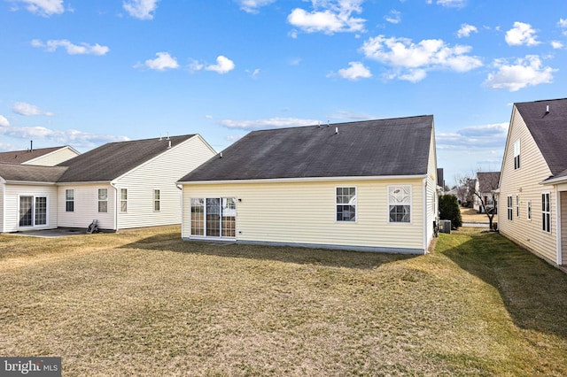 back of property with central air condition unit and a lawn