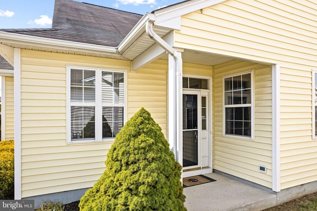 property entrance with roof with shingles