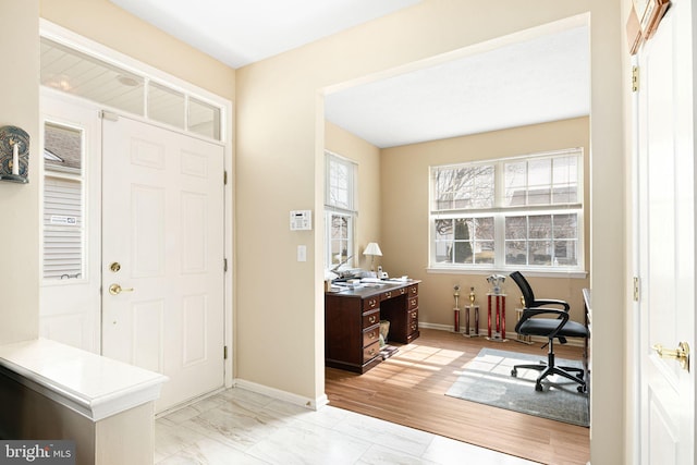 entryway with baseboards and marble finish floor