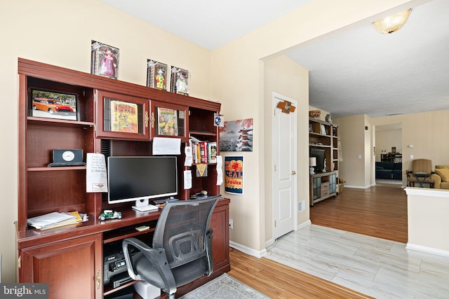 home office featuring baseboards and light wood-type flooring