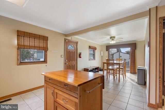 kitchen with light tile patterned floors, visible vents, butcher block countertops, and ornamental molding