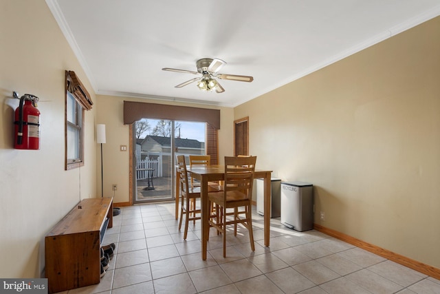 dining room featuring light tile patterned flooring, ceiling fan, crown molding, and baseboards