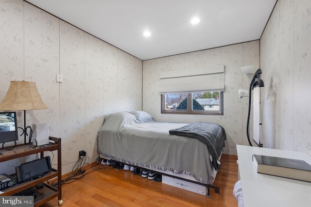 bedroom featuring recessed lighting, wood finished floors, and wallpapered walls