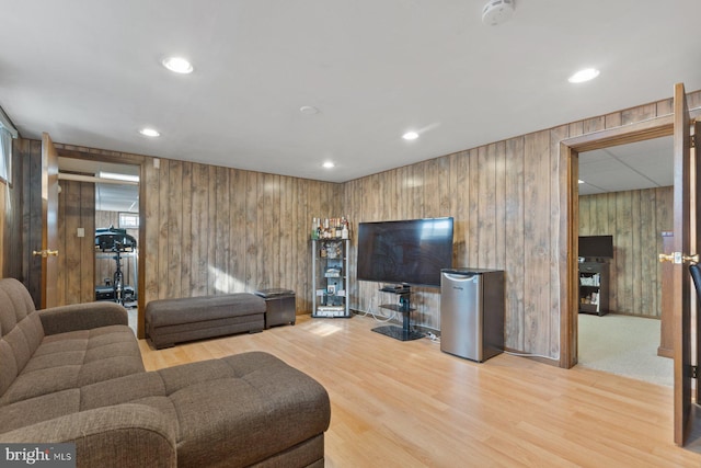 living area with wooden walls, recessed lighting, and wood finished floors