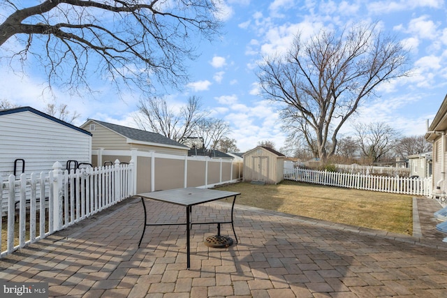 view of patio featuring a storage shed, a fenced backyard, and an outdoor structure