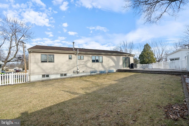 rear view of house featuring a deck, a yard, and fence