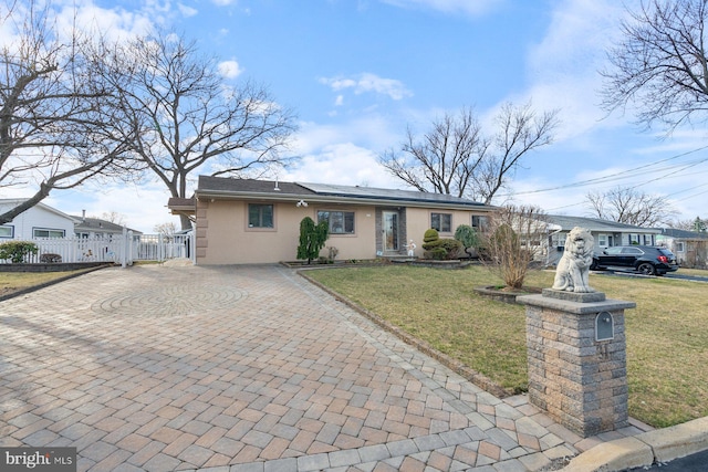 view of front of home with stucco siding, decorative driveway, a front lawn, and fence