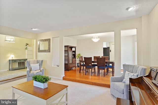 living area featuring light carpet and baseboards